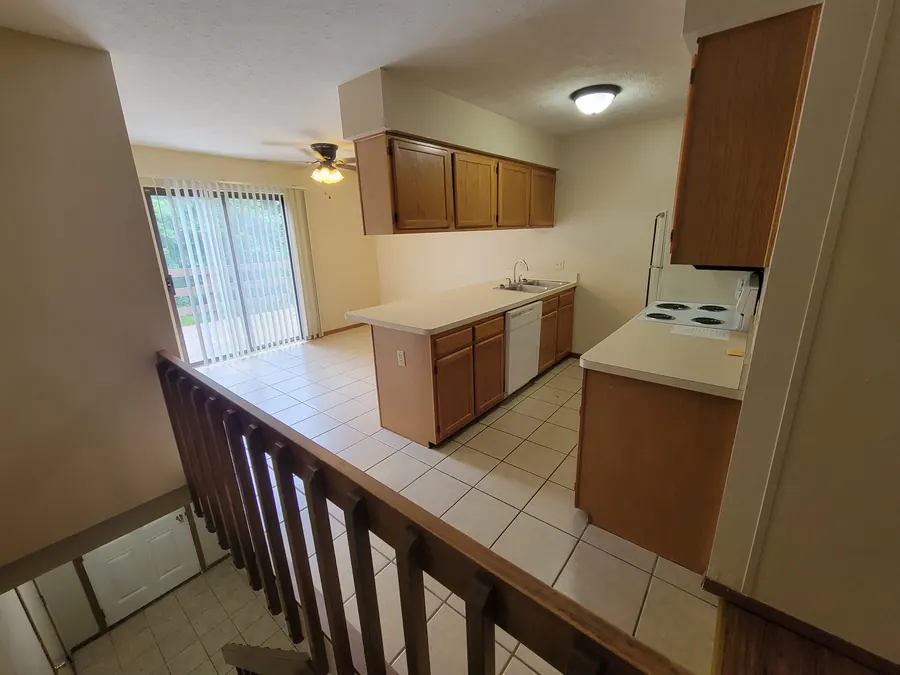 Deluxe kitchen with wood cabinets beside the stair landing