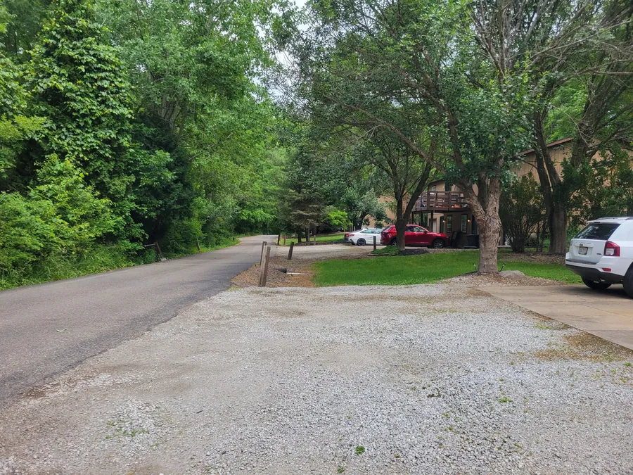 Hidden Pines townhomes and parking along a leafy drive